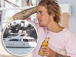 Justin Bieber dons pink T-shirt to join friends for a beer on the high seas