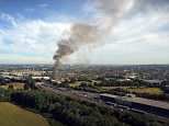 Giant clouds billow into the sky as firefighters battle huge warehouse blaze in east London