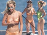 Rita Ora puts on display in two neon swimsuits in Barcelona