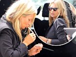 Kate Moss lights a cigarette in the rain ahead of flight to London at Mallorca airport